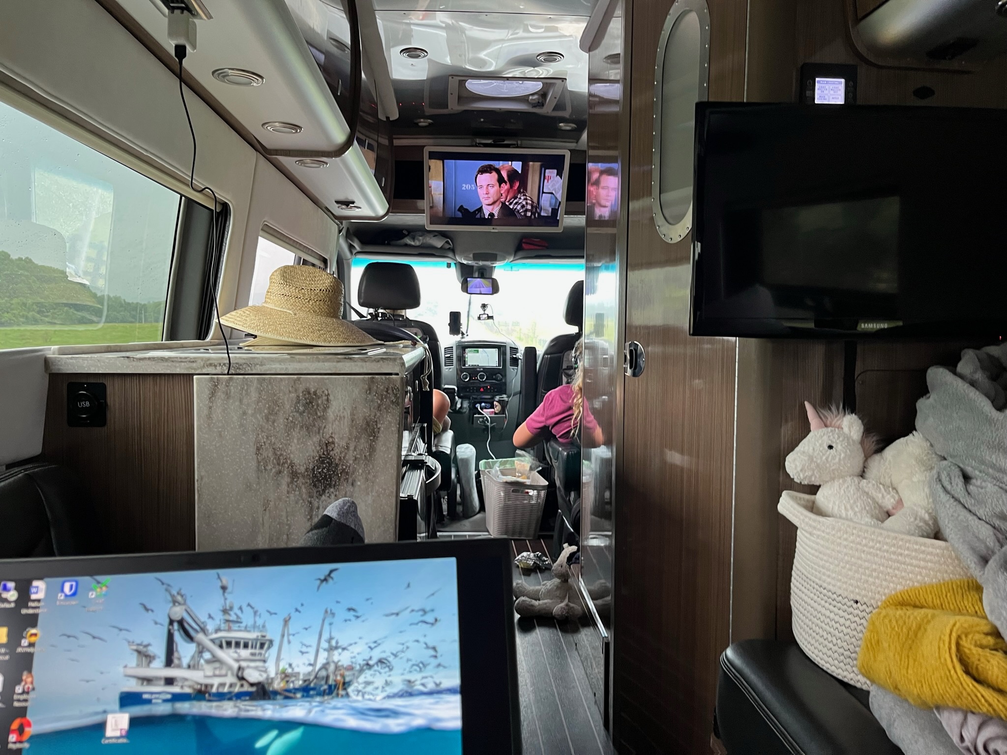 In use — TV on, laptop open, family on the road